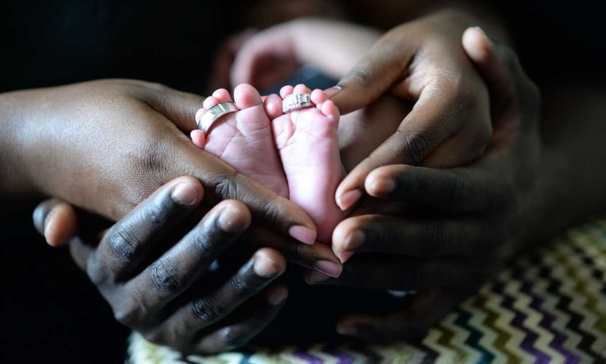 Hands of black man, wife and child